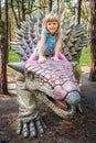 Little girl riding on Ankylosaurus dinosaur