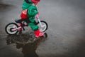 Little girl riding bike in spring water puddle Royalty Free Stock Photo