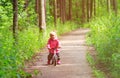 Little girl riding bike in summer forest Royalty Free Stock Photo