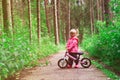 Little girl riding bike in summer forest Royalty Free Stock Photo