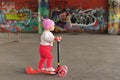 A little girl riding a children`s scooter in a skate Park Royalty Free Stock Photo