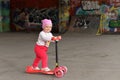 A little girl riding a children`s scooter in a skate Park Royalty Free Stock Photo