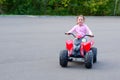 Little girl is riding on a electric quadricycle. Children`s summer vacation and entertainments