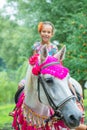 Little girl riding festive horse Royalty Free Stock Photo