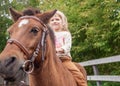 little girl riding pony without saddle on meadow in summer sunny afternoon Royalty Free Stock Photo