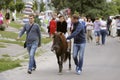 Little girl riding pony on the street, man helping leading. Kyiv, Ukraine