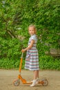 Little girl is riding a scooter Royalty Free Stock Photo