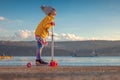 Little girl riding scooter outdoor near sea harbour Royalty Free Stock Photo