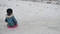 Little girl riding on snow slides rolling down the hills, in winter time winter holidays Royalty Free Stock Photo