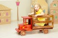 little girl is riding a toy wooden car. Royalty Free Stock Photo