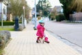 Little girl riding wooden tricycle on the street Royalty Free Stock Photo