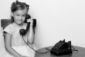 A little girl is ringing on the old phone.