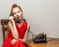 A little girl is ringing on the old phone.