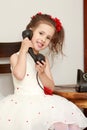 A little girl is ringing on the old phone.