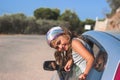 Little girl on road trip smiling and leaning out of the window; vacation and tourism background with copy space Royalty Free Stock Photo