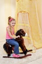 Little girl rocks on hobbyhorse