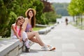 little girl on roller skates and her mother sitting in park. Royalty Free Stock Photo