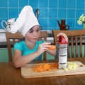 Little girl rubs carrot on grater Royalty Free Stock Photo