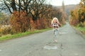 Little girl running down the road in autumn time. Happy child girl with long hair outdoors. Autumn holidays. Happy childhood.