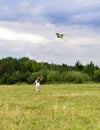 A little girl running on green grass after the bright flying kite Royalty Free Stock Photo