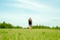 Little girl running on a meadow in a field of flowers, Summer day. barefoot jumping on the grass, happy laughs. Horizon Royalty Free Stock Photo