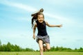 Little girl running on a meadow in a field of flowers, Summer day. barefoot jumping on the grass, happy laughs. Horizon Royalty Free Stock Photo