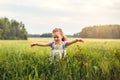 Little girl runs through a green meadow