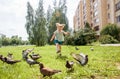 A little girl runs for pigeons.Baby Girl Chasing Pigeons In Outdoors City Park. cheerful happy childhood, runs laughing Royalty Free Stock Photo