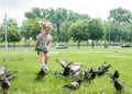 A little girl runs for pigeons.Baby Girl Chasing Pigeons In Outdoors City Park. cheerful happy childhood, runs laughing Royalty Free Stock Photo