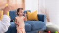 A little girl runs and plays with a small soap bubble that his mother blows for him to play with. In the living room Royalty Free Stock Photo