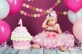 The little girl`s birthday girl was smeared into a cake. The first cake. The use of the first cake. Smash cake. Royalty Free Stock Photo