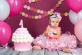 The little girl`s birthday girl was smeared into a cake. The first cake. The use of the first cake. Smash cake. Royalty Free Stock Photo