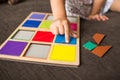 Little girl`s hands playing with a wood mosaic on a sofa. Educational games. Montessori Preschool early develop Royalty Free Stock Photo