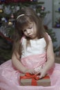 little girl is sad by the christmas tree. the child does not like the gift Royalty Free Stock Photo