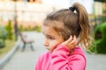 A little girl with a sad and frightened face holds her cheek with her hand - a tooth hurts. Ear pain, toothache, swollen cheek and Royalty Free Stock Photo