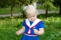 Little girl in sailor blue dress walk in the park.