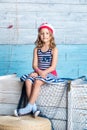 Little girl sailor sitting on box