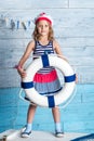 Little girl sailor standing and keeps lifebuoy