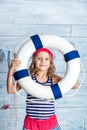 Little girl sailor standing and keeps lifebuoy