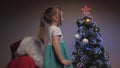A little girl and Santa Claus hang beautiful balls on the tree. Merry Christmas. Child and Santa Claus decorate the Royalty Free Stock Photo