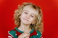 Little girl in Santa elf helper costume on bright red vivid color background Royalty Free Stock Photo