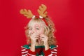 Little girl in Santa elf helper costume on bright red vivid color background Royalty Free Stock Photo