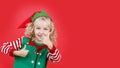 Little girl in Santa elf helper costume on bright red vivid color background Royalty Free Stock Photo