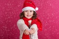 Little girl in santa hat is holding fake snow Royalty Free Stock Photo