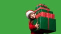 A little girl in a Santa hat is holding a lot of gift boxes. New Year& x27;s gifts for Christmas. 2023. Isolated on a Royalty Free Stock Photo