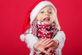 Little girl in santa hat and scarf on red background Royalty Free Stock Photo