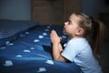 Little girl saying bedtime prayer near bed in room Royalty Free Stock Photo