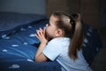 Little girl saying bedtime prayer near bed in room Royalty Free Stock Photo