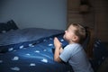 Little girl saying bedtime prayer near bed in room Royalty Free Stock Photo