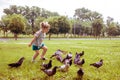 Little girl scares pigeons fun game summer. ecology, runs on the grass in the city park outdoors, lifestyle Royalty Free Stock Photo